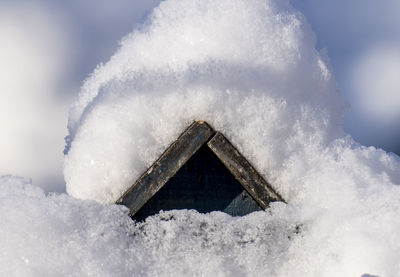 A bird house covered in snow