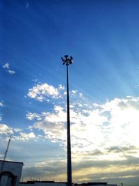 Low angle view of street light against blue sky