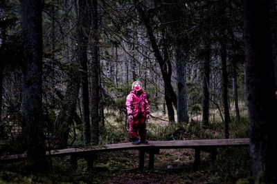 Young girl standing on a boardwalk in a forest in sweden