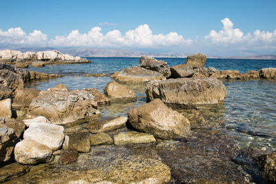 Rocks on beach against sky