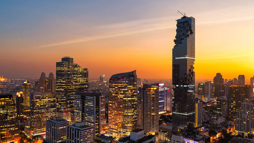 High angle view of city lit up at sunset