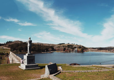 View of statue by sea against cloudy sky