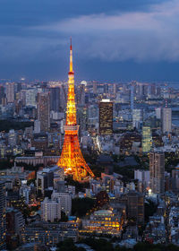 Aerial view of illuminated buildings in city against sky