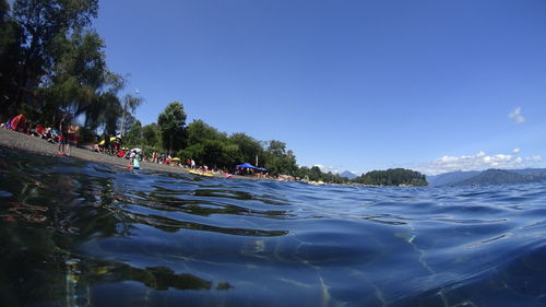 People swimming in sea against sky