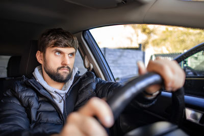 Portrait of young man driving car