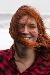 Close up happy redhead woman with messy hair on beach portrait picture