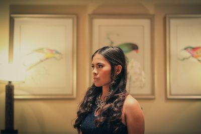 Close-up of young woman looking away against picture frames in museum