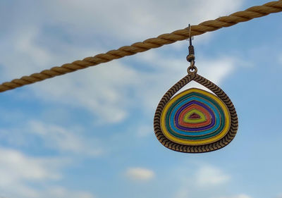 Abstract, delhi, india- low angle view of multi colored earring hanging against sky