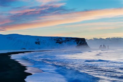 Scenic view of snowcapped mountains against sky during sunset