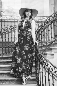 Portrait of woman wearing hat standing on steps