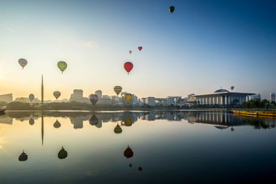 Hot air balloon flying over water against clear sky