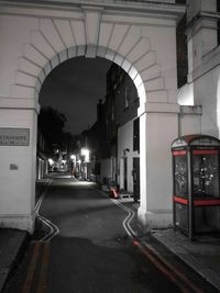 Road leading towards illuminated city at night