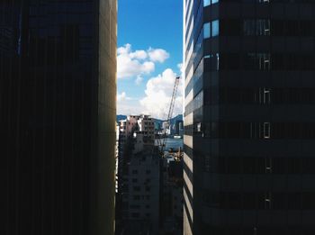 Buildings in city against cloudy sky
