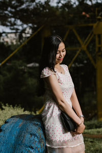 Young woman standing against wall