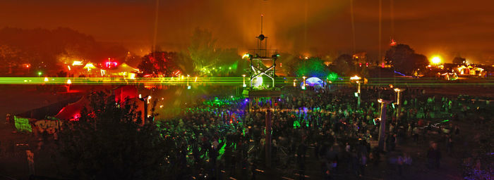 Crowd at illuminated city against sky at night