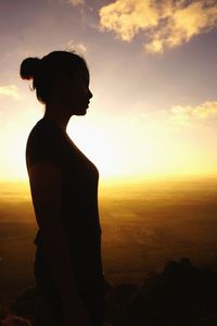 Side view of silhouette man standing against sky during sunset