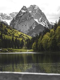 Scenic view of lake by mountains against sky