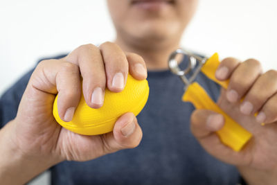 Cropped hand of woman holding toy against white background