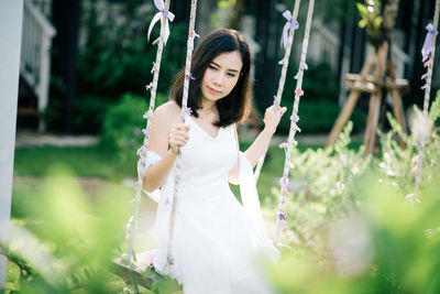 Woman sitting on swing at park