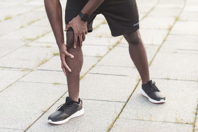 Low section of man standing on footpath