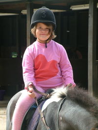 Portrait of girl sitting on horse