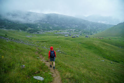 Woman hiking on alpine footpath in the rain in the austrian alps