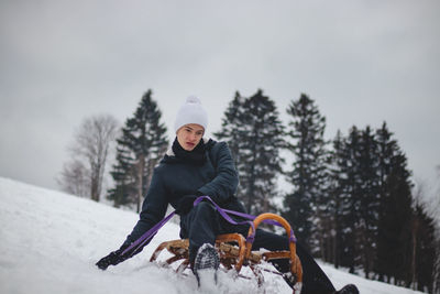 Man sitting on snow covered land