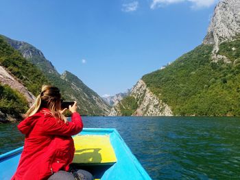 Woman photographing sea against sky