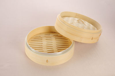 High angle view of eggs in basket on table against white background