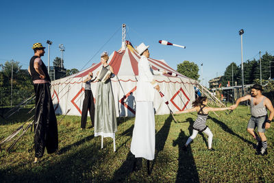 Male and female artists performing together on meadow