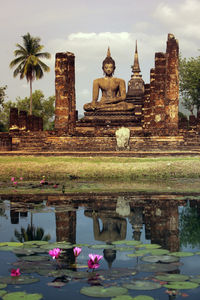 Large buddha statue with lake in foreground