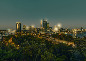 Illuminated buildings in city against sky at night