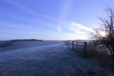 Scenic view of snow covered landscape against blue sky