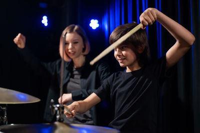 Portrait of smiling young man playing drum at home