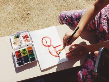 Midsection of girl painting on paper