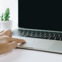 Midsection of man using laptop on table