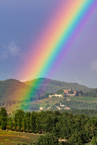 Scenic view of rainbow over landscape against sky