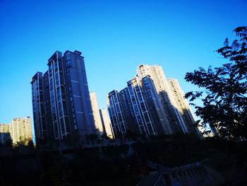 Low angle view of modern buildings against clear blue sky