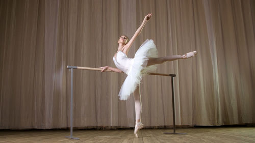 Ballet rehearsal, in old theater hall. young ballerina in white ballet skirt, tutu