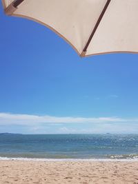 Scenic view of beach against blue sky