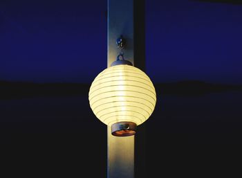 Close-up of illuminated lantern against clear blue sky