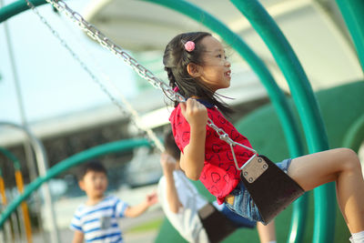 Side view of girl swinging at playground