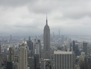 Modern buildings in city against cloudy sky