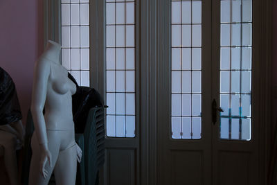 Woman standing by window at home