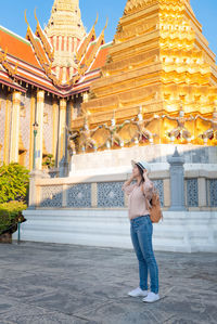 Full length of man standing outside temple against building