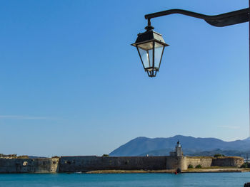 Street light by sea against clear sky