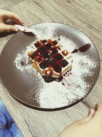 High angle view of hand holding ice cream on table