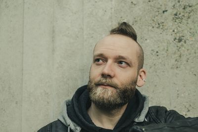 Man with spiky hair against wall