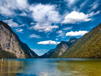 Scenic view of lake by mountains against sky