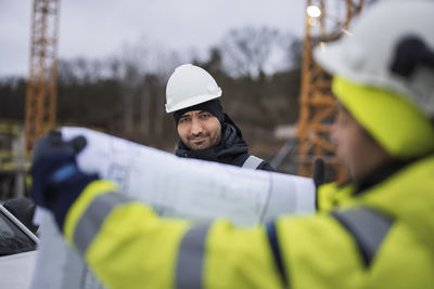 Construction engineers discussing project at construction site